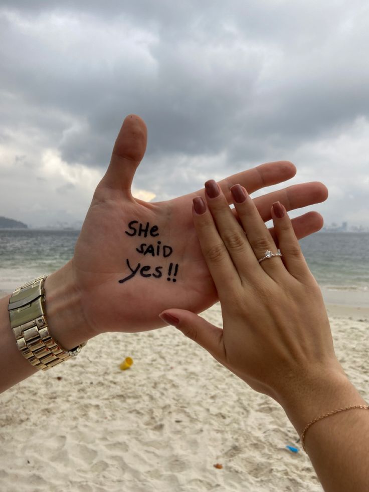 two people holding up their hands with the words she said yes written on each hand