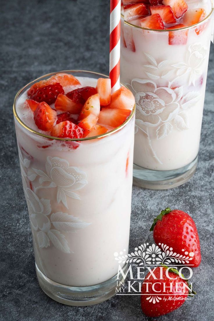 two glasses filled with milk and strawberries