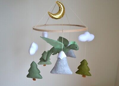 a crib mobile with trees and a crescent hanging from it