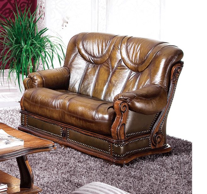 a brown leather couch sitting on top of a rug next to a wooden coffee table