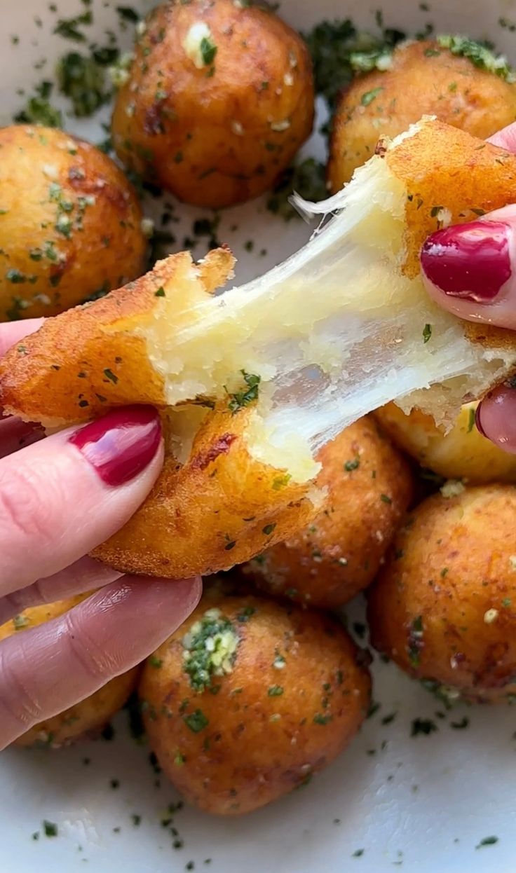 a person is eating some kind of appetizer with parmesan cheese on it