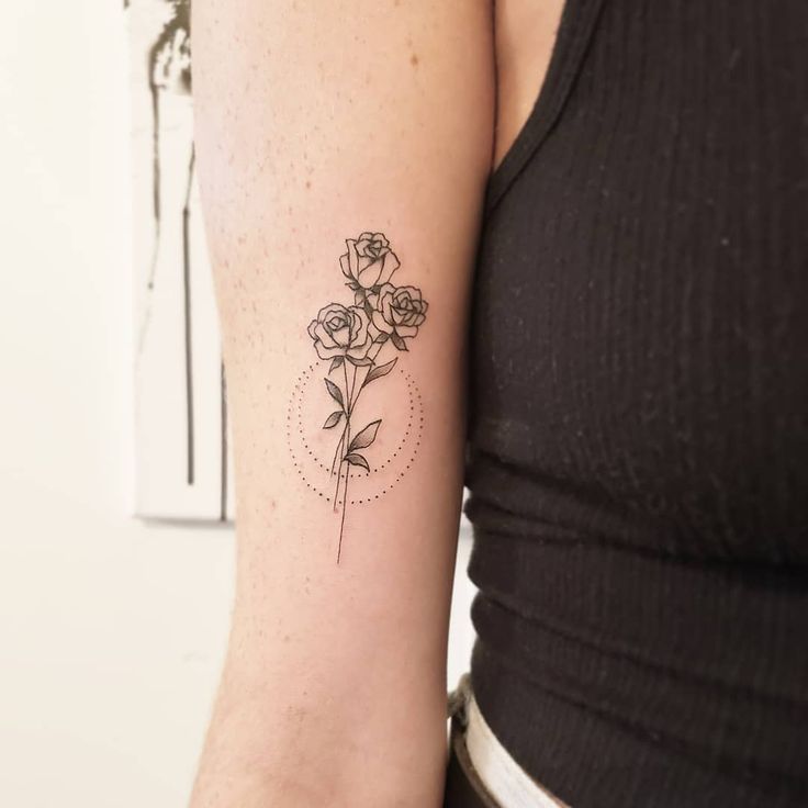 a woman's arm with a flower tattoo on the left side of her arm