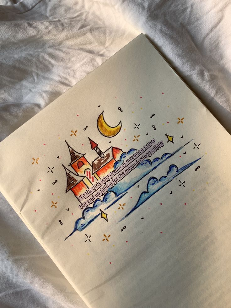 an open book with a drawing of a castle on the page and stars around it