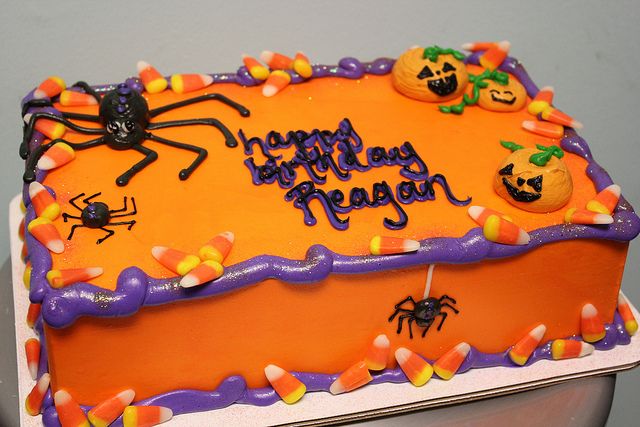 a birthday cake decorated with candy and pumpkins for a halloween themed party or celebration