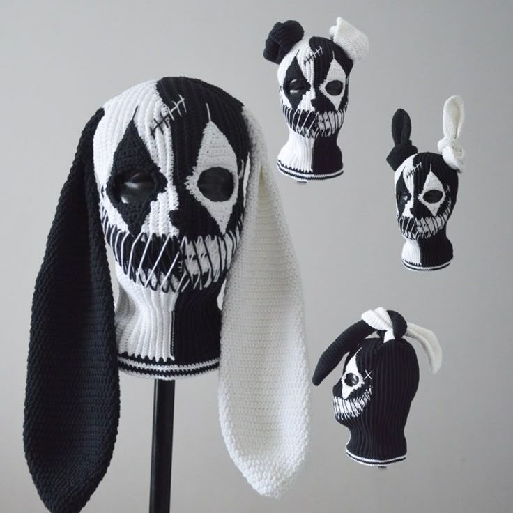 a knitted skull hat with ears and tail is shown in three different colors, including black and white