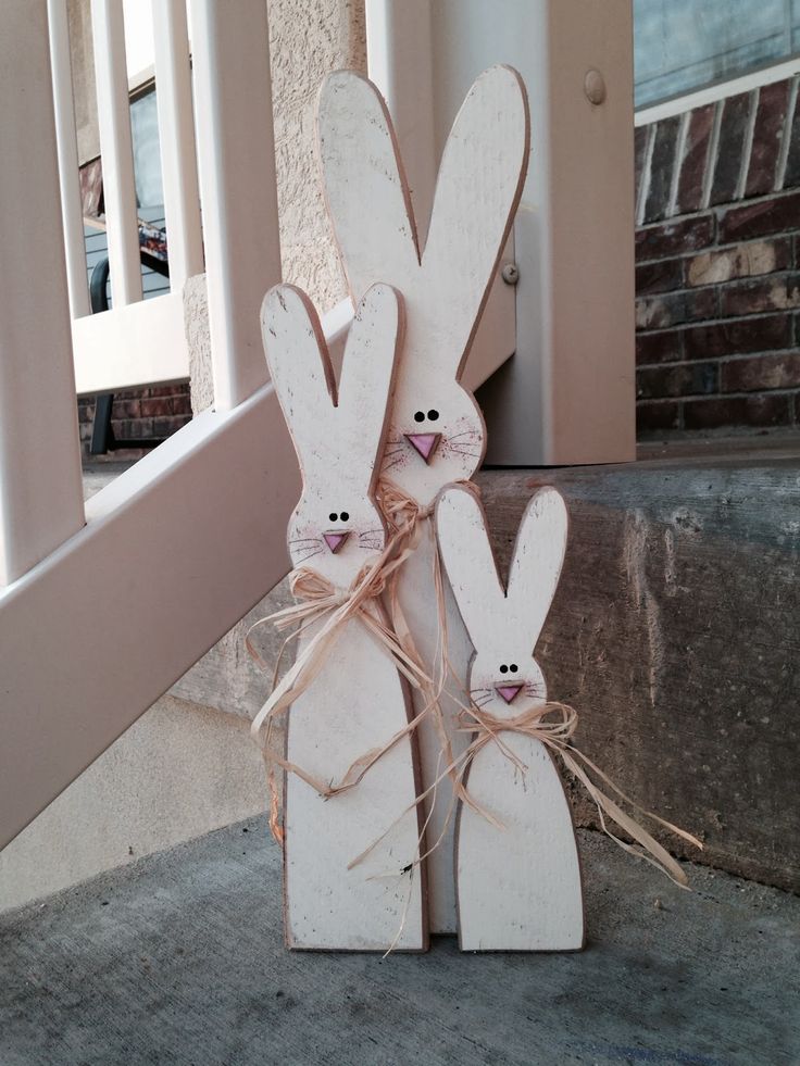 two wooden rabbits tied to each other on the front steps in front of a house