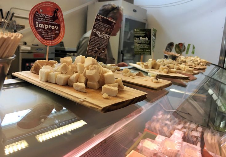 cheeses and other food items are on display in a deli or bakery shop