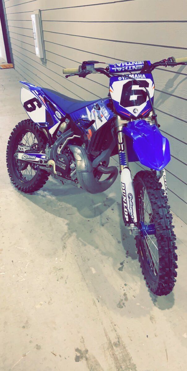 a blue dirt bike parked in front of a garage door with the number 29 on it