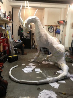 a white paper mache horse in a room filled with clutter and other items