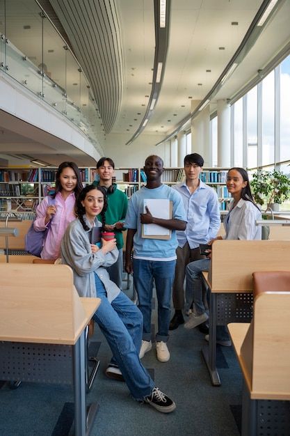 a group of people standing around each other in a room with desks and bookshelves