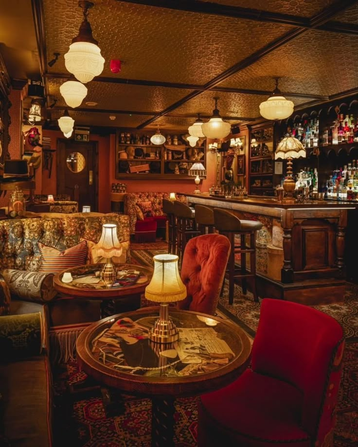 a dimly lit bar with red chairs and tables