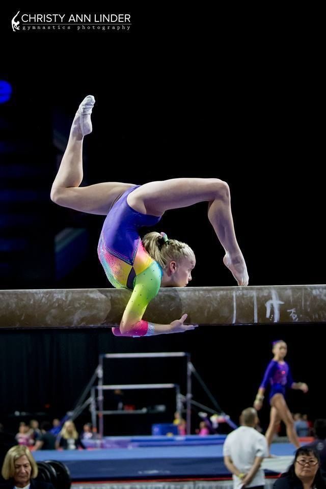 a woman is doing gymnastics on the beam