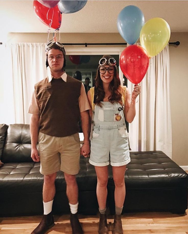 a man and woman standing next to each other with balloons attached to their heads in front of them