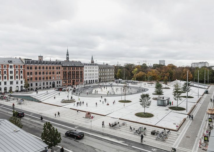 an aerial view of a city square with people walking around