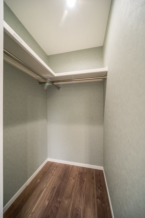 an empty closet with wooden floors and white walls