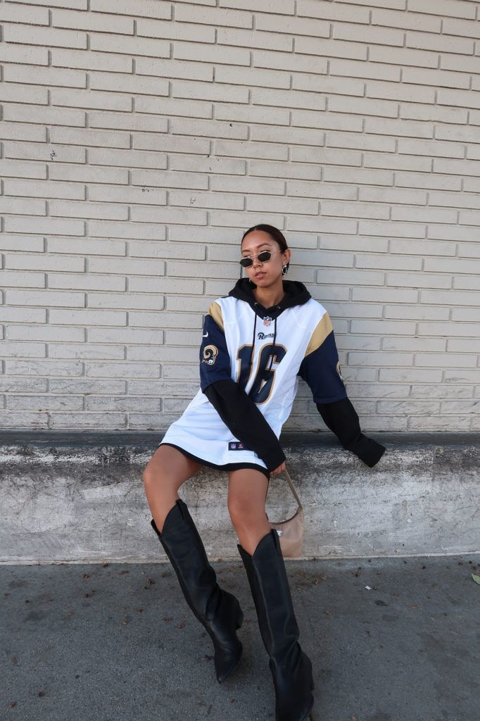 Styling Jerseys With Nike Skirt And Jersey Outfit Winter, White Football Jersey Outfit, Saints Game Outfit, Styling A Football Jersey Women, Oversize Jersey Outfit, Styling Jersey Women, Jersey And Boots Outfit, Cold Sports Game Outfit, Baltimore Ravens Outfit Women