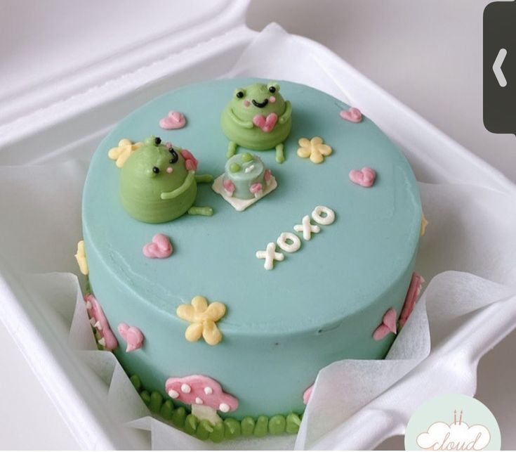 there is a cake with two frogs on it