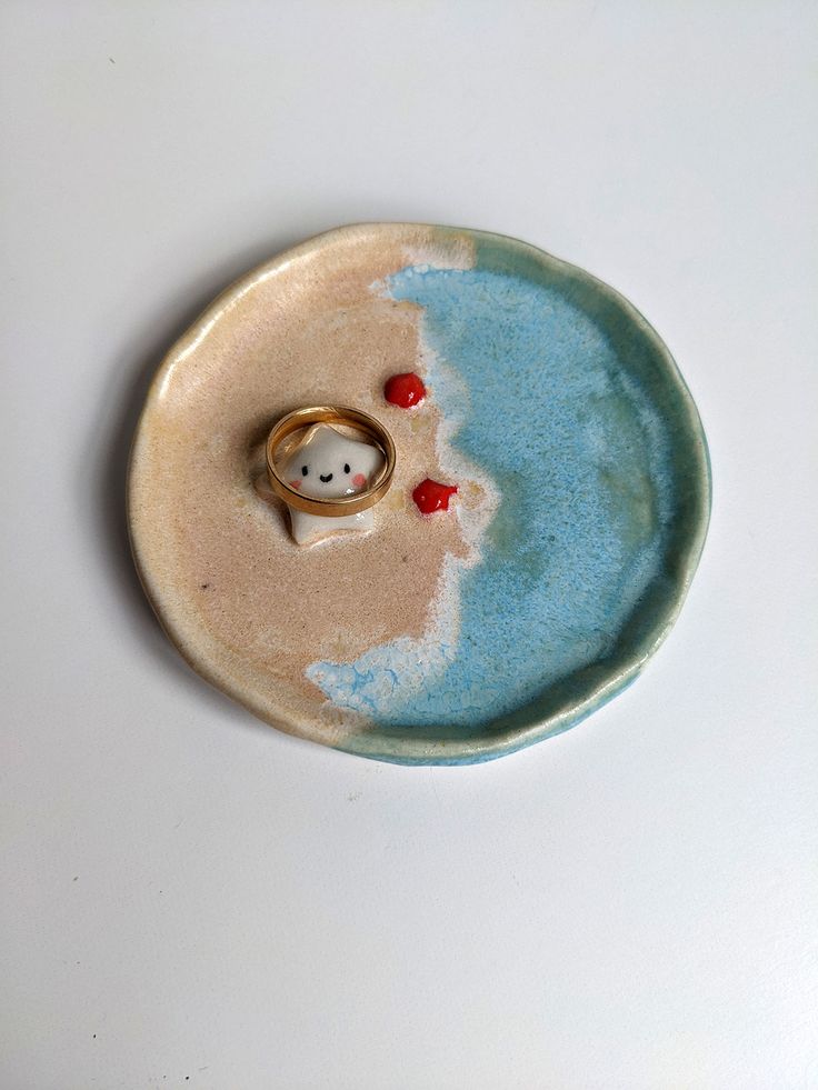 a ceramic ring dish with two rings on it