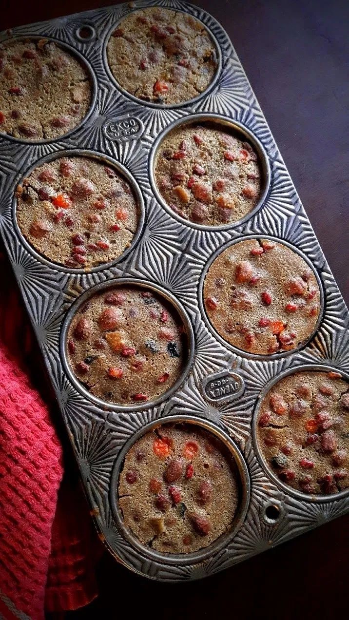 a muffin tin filled with lots of different types of baked goods on top of a wooden table