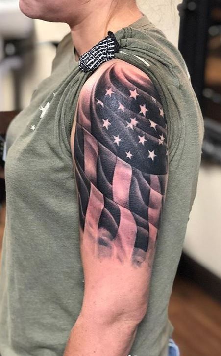 a woman with a black and grey american flag tattoo on her left upper half arm