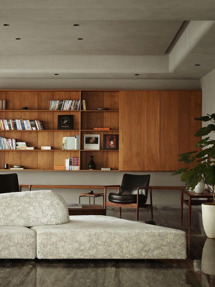 a living room filled with lots of furniture and bookshelves on top of wooden shelves