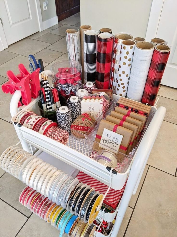 a white cart filled with lots of different types of wrapping paper and ribbon on top of each other