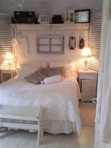 a white bed sitting in a bedroom next to two lamps