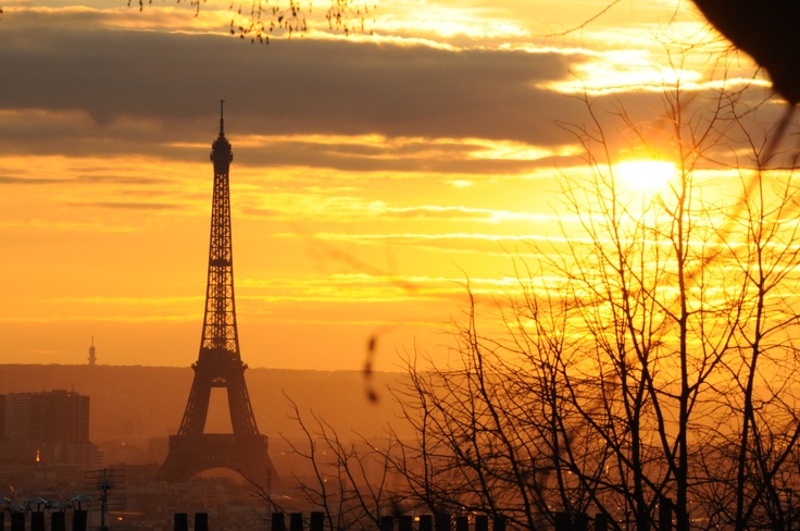 the eiffel tower is silhouetted against an orange and yellow sky at sunset