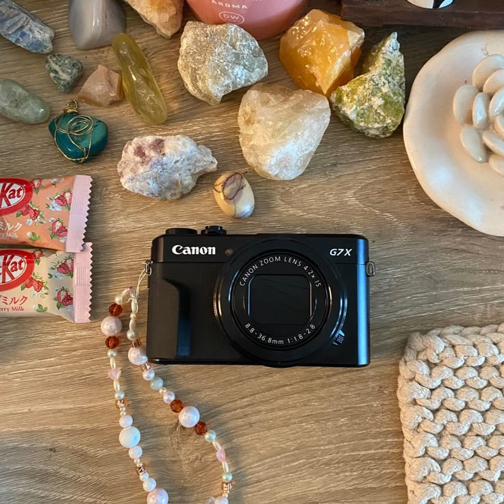 a camera sitting on top of a wooden table next to some rocks and other items