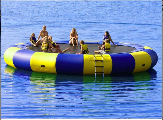 four people are sitting on an inflatable raft that is floating over the water