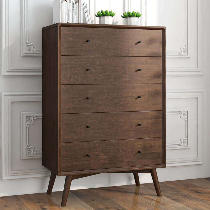 a wooden chest of drawers sitting on top of a hard wood floor