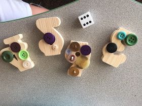 several wooden toys are arranged on a table with dices and buttons in the shape of animals