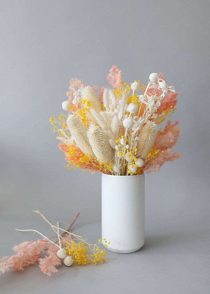 an arrangement of flowers in a white vase