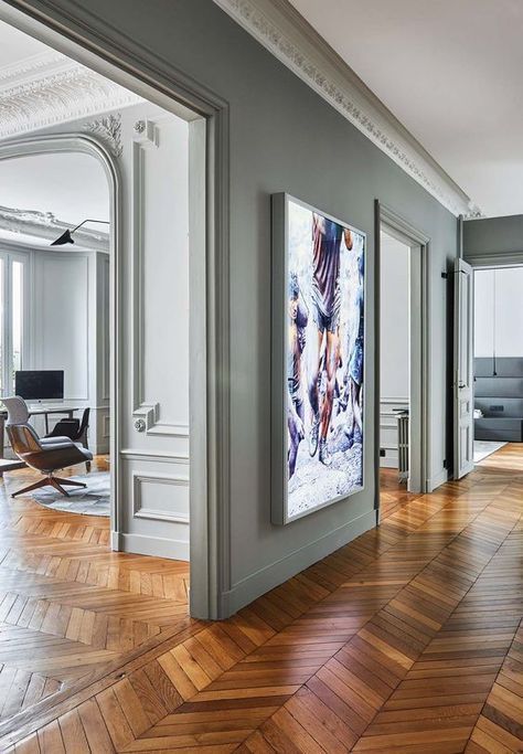 an empty room with wood floors and paintings on the wall