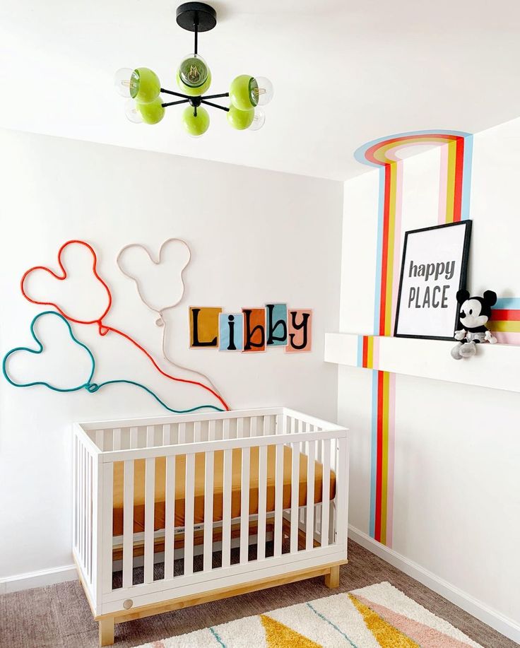 a baby's room with mickey mouse wall art