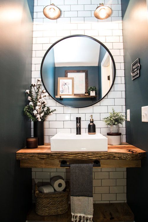 a bathroom sink with a mirror above it and towels on the shelf next to it