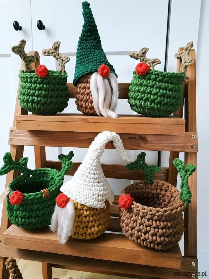 crocheted christmas baskets are sitting on a shelf