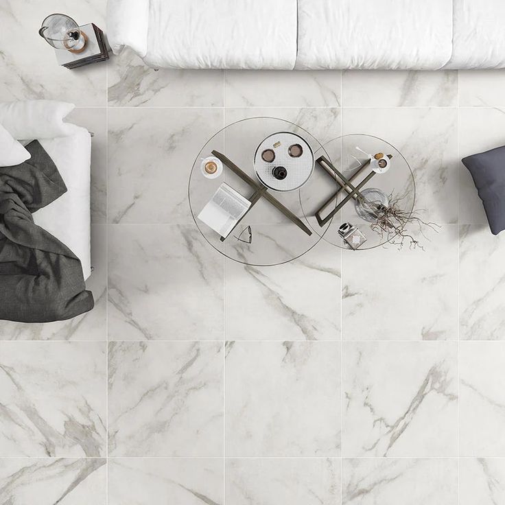 an overhead view of a bedroom with marble flooring and white bedding on the side