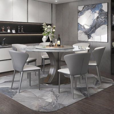 a dining room table surrounded by white chairs