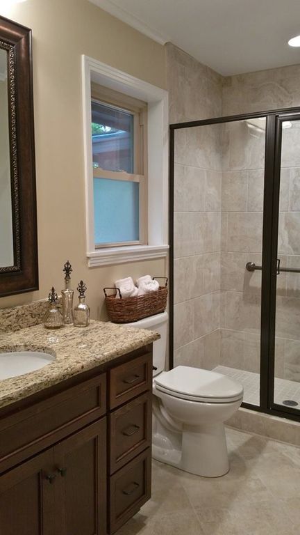 a bathroom with a sink, toilet and shower stall in the middle of the room