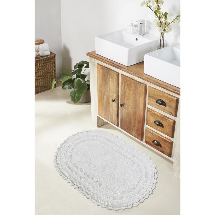 a bathroom with two sinks and a rug on the floor