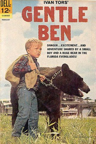 an old magazine cover with a young boy holding a black bear on a chain in the grass