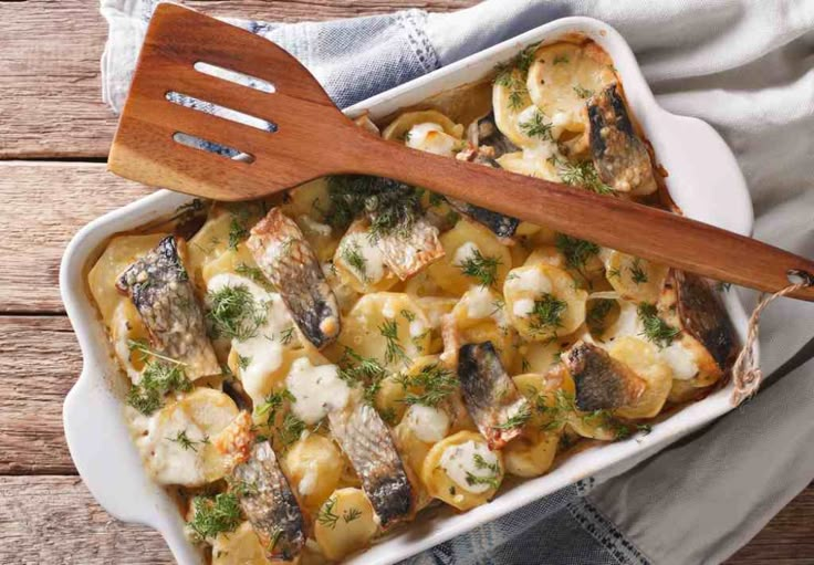 a casserole dish with mushrooms and broccoli in it on a wooden table