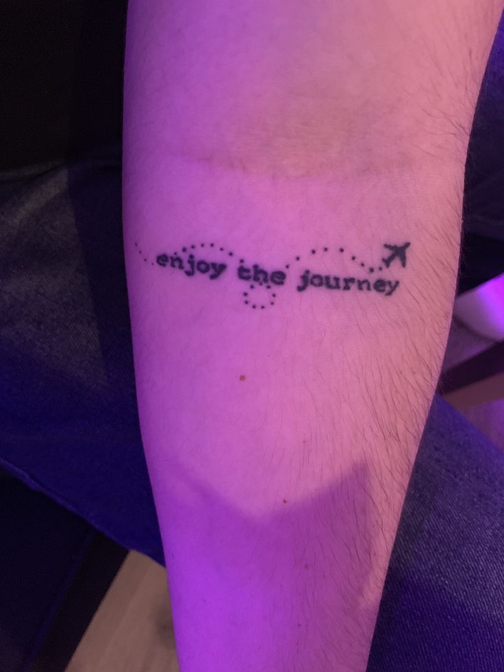 a person with a tattoo on their arm that says enjoy the journey