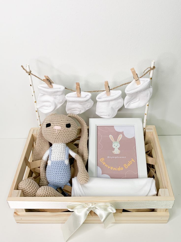 a stuffed animal in a wooden box with clothes hanging on the clothes line above it