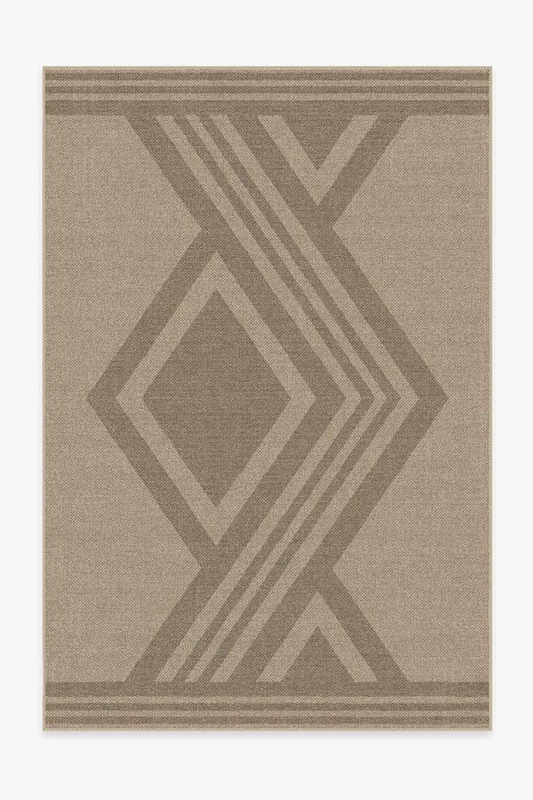 a beige rug with an abstract design on the bottom and sides, in grey tones