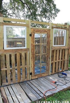 a house made out of wooden pallets and windows