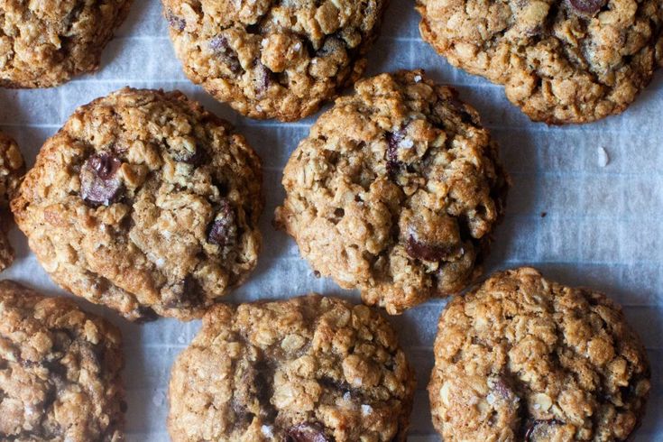 several oatmeal cookies sitting on top of a piece of parchment paper next to each other