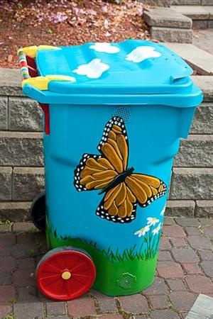 a blue trash can with a butterfly painted on it