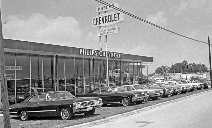 an old black and white photo of several cars parked in front of a chevrolet dealership